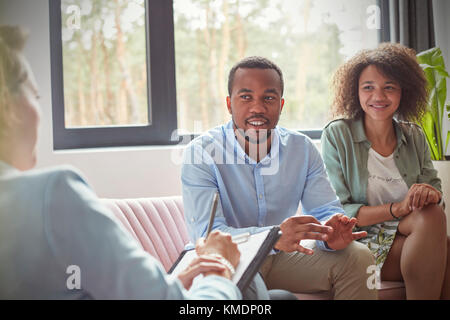 Couple listening to female therapist in couples therapy counseling session Stock Photo