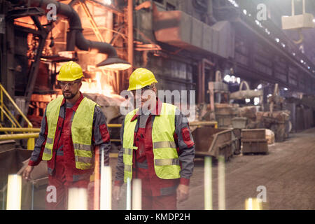 Steelworkers walking in steel mill Stock Photo