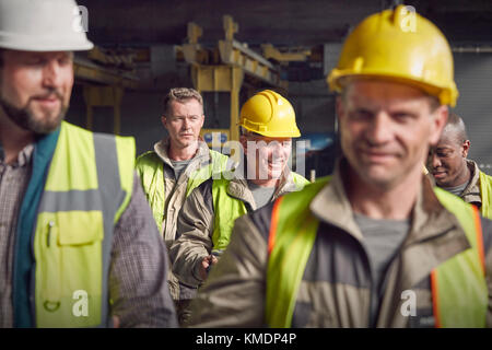 Steelworkers walking in steel mill Stock Photo