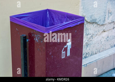 Close up red metal garbage bin with white sign on Stock Photo