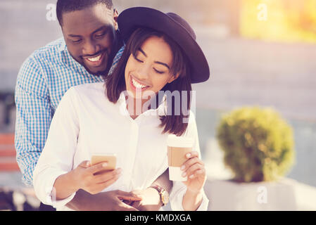 Happy young woman being hugged by her boyfriend Stock Photo