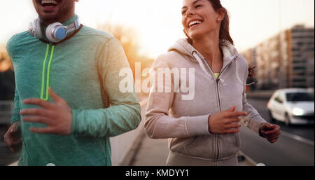 Young fitness couple running in urban area Stock Photo