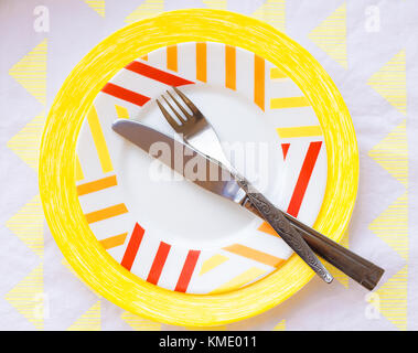 table setting with bright colored plate, knife and fork Stock Photo