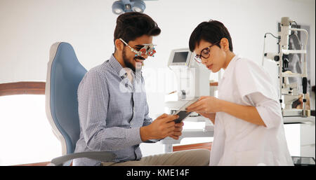 Woman doing eye test with optometrist in eye sight clinic Stock Photo