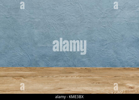 Empty wooden deck table over blue painted wall Stock Photo