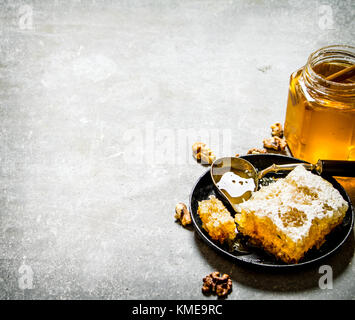 Honey background. Fresh honey and walnuts . On a stone background Stock Photo