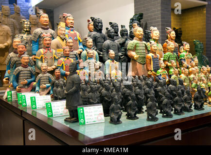 Catapulted into international tourism with the 1974 discovery of fields of buried life-size terracotta warriors,Xi'an today caters to a huge tourist trade with souvenir statues such as these,on sale in a state-run store.Xian is the capital of Shaanxi Province,People's Republic of China.It is the oldest of the Four Great Ancient Capitals,having held the position under several of the most important dynasties in Chinese history,including Western Zhou,Qin,Western Han,Sui,and Tang.Xi'an is the starting point of the Silk Road Stock Photo