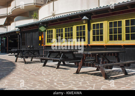 Pub or Bar Exterior with Wooden Tables in Open Air. Stock Photo