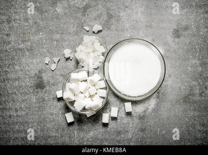Different types of white sugar in a glass . On a stone background. Stock Photo