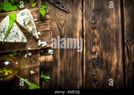 Bottle with white wine and blue cheese on a cutting Board. Stock Photo