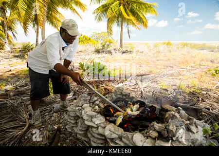 Cooking lunch on coconut frond fire, Kiribati Stock Photo