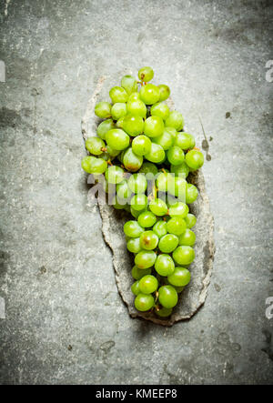 Branch of white grapes. On the stone table. Stock Photo