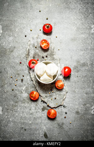 Fresh mozzarella with tomatoes and spices. On the stone table Stock Photo