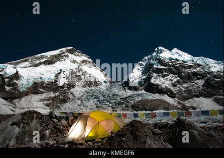 Lit tent at night beneath Khumbu Icefall at Mount Everest with West Shoulder of Everest on left and Nuptse on right, Solukhumbu District, Nepal Stock Photo