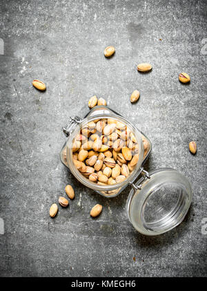 Pistachios in the jar. On the stone table. Stock Photo