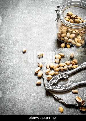 Pistachios in the jar with the Nutcracker. On the stone table. Stock Photo