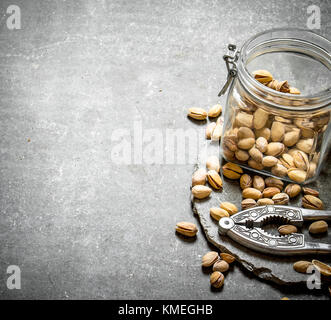 Pistachios in the jar with the Nutcracker. On the stone table. Stock Photo