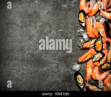 Shrimp and mussels with ice. On a stone background. Stock Photo