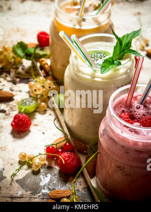 Berry smoothie made from currants, gooseberries and raspberries with nuts. On rustic background. Stock Photo