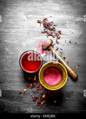 tea with pomegranate crushed in a mortar. On a black wooden background. Stock Photo
