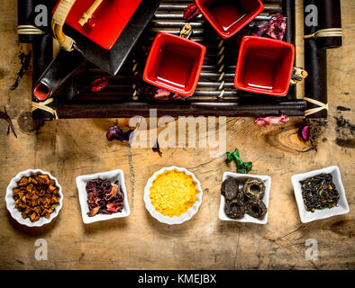 Different types of dried tea in the cups . On wooden background. Stock Photo
