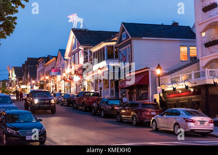 Bar Harbor, USA - June 8, 2017: People walking sidewalk street by Main road in downtown village during evening night Stock Photo