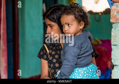 A young girl holding a toddler in her arms. Stock Photo