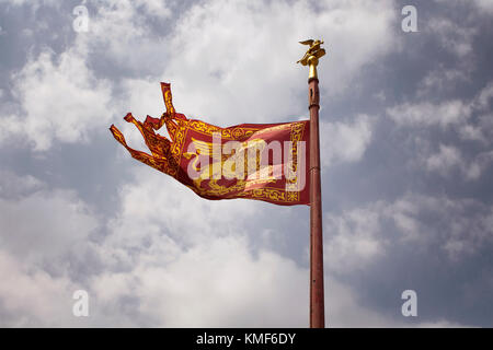 View of historical Venetian flag waving with cloudy sky background.