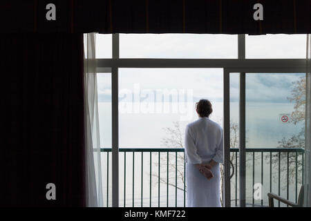 Woman overlooking lake from balcony.  Harrison Hot Springs, BC Canada Stock Photo