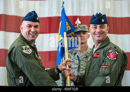 Lt. Col. Gerald Cook, left, outgoing 76th Fighter Squadron commander (FS), presents Lt. Col. Brandon Kelly, incoming 76th FS commander with a guidon during an Assumption of Command ceremony, Dec. 3, 2017, at Moody Air Force Base, Ga.. An Assumption of Command is a military tradition that represents a formal assumption of a unit’s authority and responsibility by a commander. Stock Photo