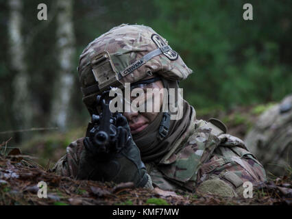 Private 1st Class Juan Cervera, a petroleum supply specialist and Arlington, Texas native assigned to 1st Battalion, 7th Field Artillery Regiment, 2nd Armored Brigade Combat Team, 1st Infantry Division practices pulling security for an ammunition distribution point while training near Torun, Poland during Atlantic Resolve Dec. 5, 2017. Atlantic Resolve is a U.S. endeavor to fulfill NATO commitments by rotating U.S.-based units throughout the European theater to deter aggression against NATO allies in Europe. Stock Photo