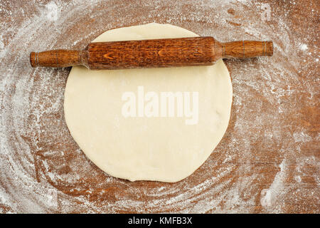 Rolled out dough on table with rolling pin. Stock Photo