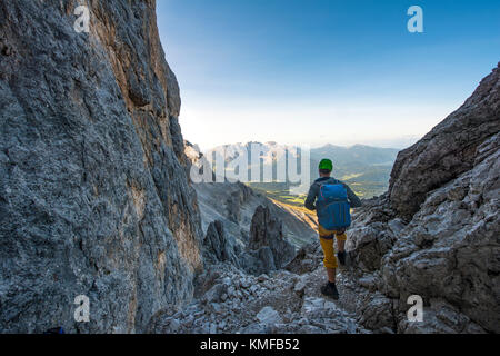 Hiker in the Santner via ferrata, rose garden group, view of the Latemar Group, Dolomites, South Tyrol, Trentino-Alto Adige Stock Photo