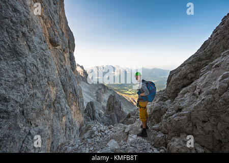 Hiker in the Santner via ferrata, rose garden group, view of the Latemar Group, Dolomites, South Tyrol, Trentino-Alto Adige Stock Photo