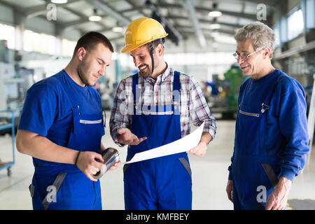 Team Of Engineers Having Discussion In Factory Stock Photo