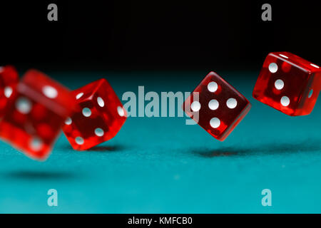 Picture of several red dice falling on green table Stock Photo