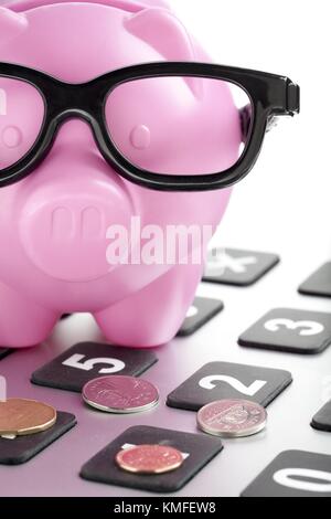piggy bank on the top of the calculator with coins