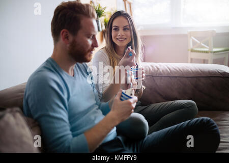 Romantic couple eating ice cream together and watching tv Stock Photo