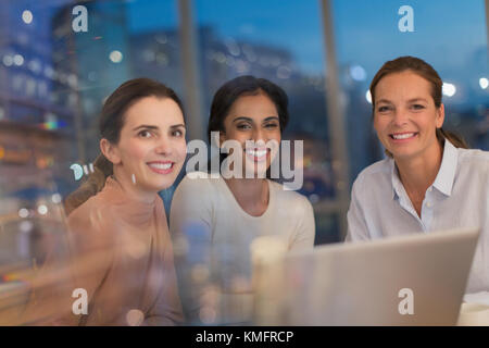 Portrait smiling, confident businesswomen working ate at laptop in conference room meeting Stock Photo