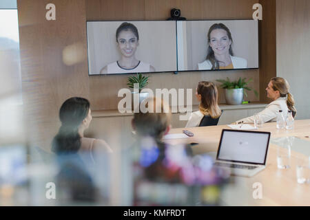 Business people talking on monitors in video conference Stock Photo
