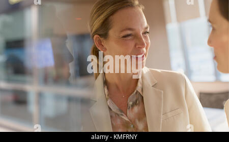Smiling businesswoman talking to colleague Stock Photo