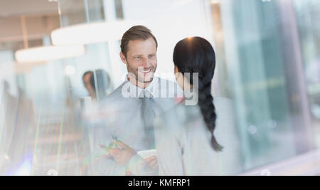 Smiling businessman talking to colleague in office Stock Photo