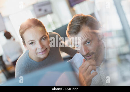 Businessman and businesswoman working at computer in office Stock Photo
