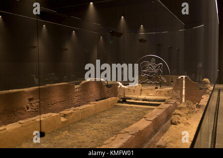 Atmospheric lighting helps display the reconstructed mid-3rd century Roman Mithraeum also known as the Temple of Mithras, Walbrook where bull-sacrifice was practised, now beneath Bloomberg's new European headquarters and open to the public, on 26th November 2017, in the City of London, England. Stock Photo