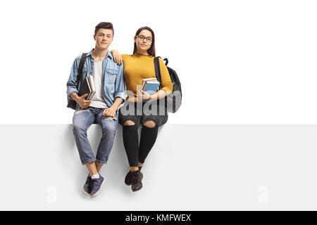 Teenage students sitting on a panel isolated on white background Stock Photo