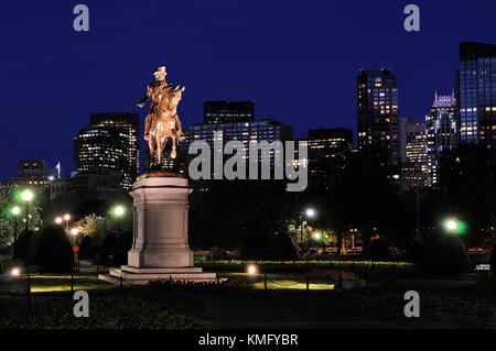 George Washington statue in Boston Public Garden at night against deep blue sky and city skyline background. Stock Photo