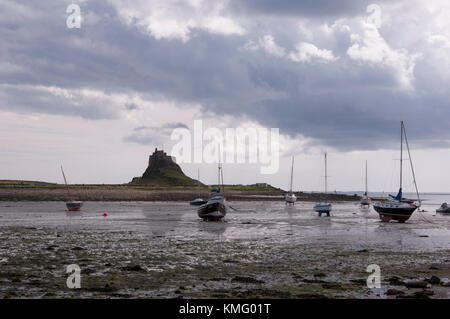 Looking to Lindisfarne Priory, at Holy Island in Northumberland on the North East coast of England, when the tide has receded. Stock Photo