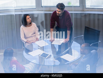 Businessman with paperwork leading conference room meeting Stock Photo