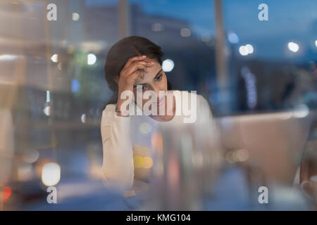 Tired businesswoman working late at laptop in office at night Stock Photo