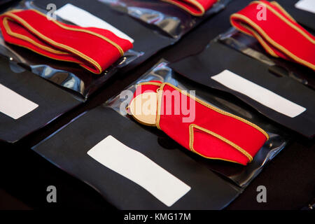 gold medals with red ribbons lined up for presentation at ceremony Stock Photo